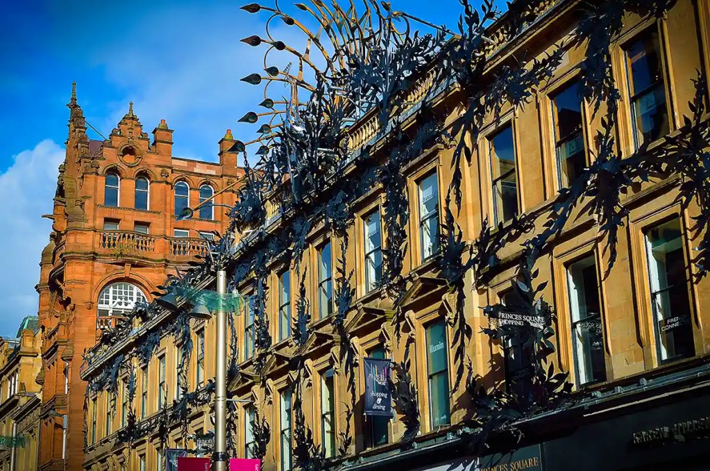 Historic buildings and decorative metal artwork along Buchanan Street shopping district in central Glasgow.